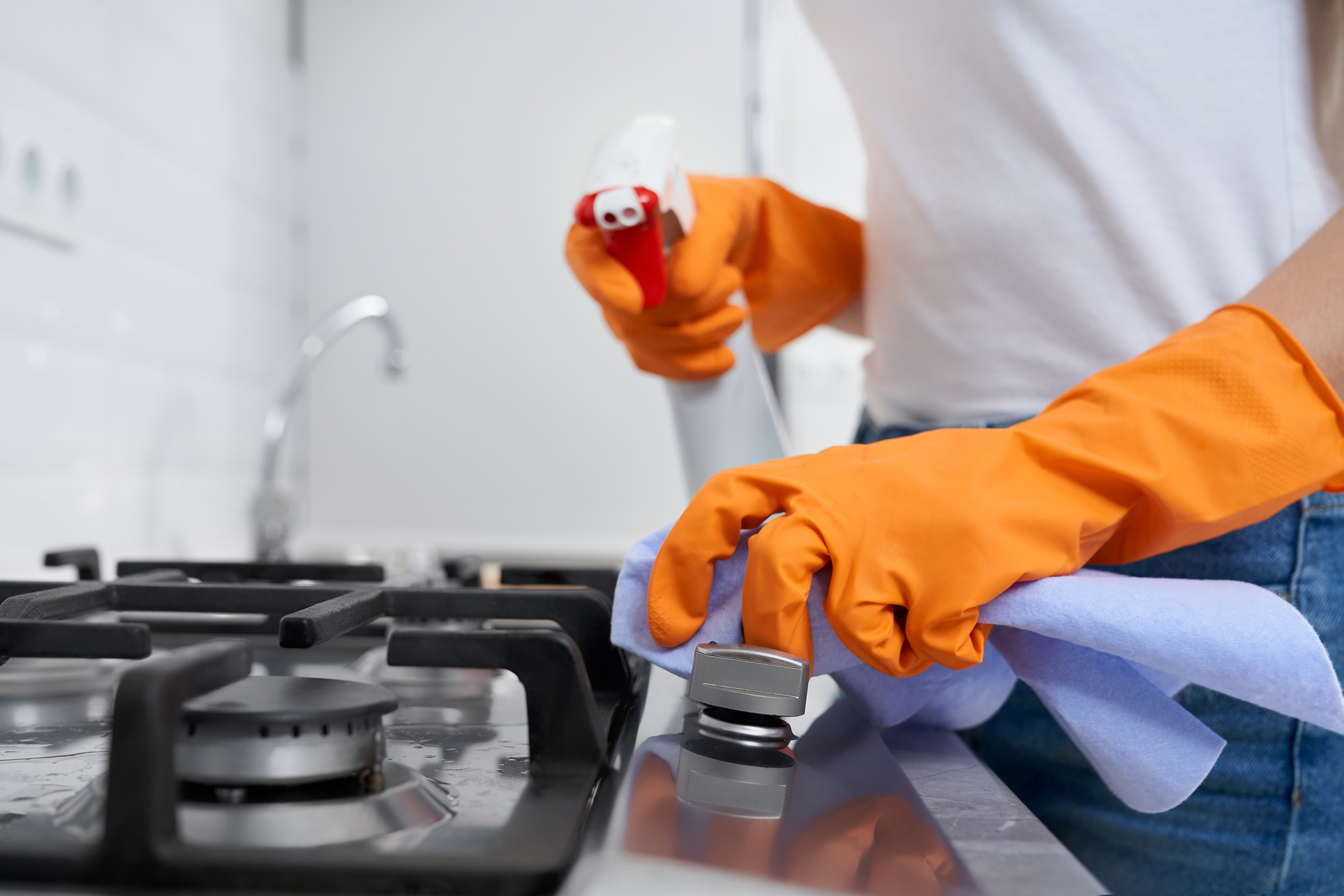 Person Cleaning Kitchen Stove